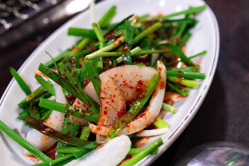 spicy seasoned vegetable salad composed of fresh chives and white onion. A Korean side dish