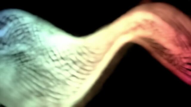 An abstract image features blended colors of blue, green, and yellow on a dark background. It shows an ambiguous shape with subtle textures and gradients