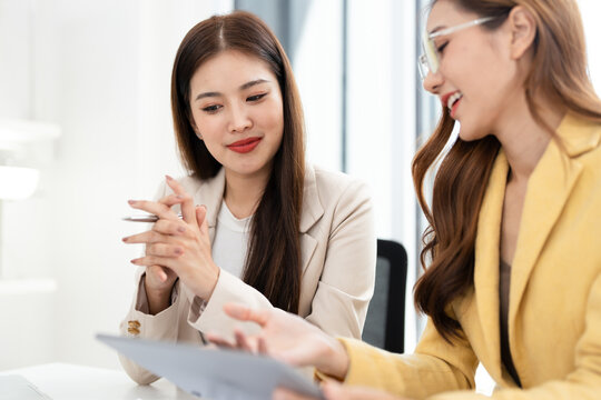 Business partners working with analysis report and advisor showing plan, Two businesswoman working with Financial analysts reports and planning investment at office.