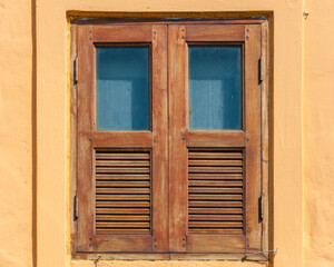 closed wooden window on orange wall