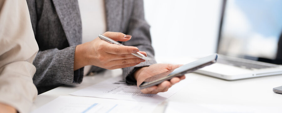 Close up hands of Young  businesswoman showing business data on her phone to  colleague, share news, learn new AI app