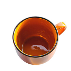 Overhead view of an empty orange ceramic mug with a dark rim and handle casting a shadow on a stark black background under bright studio lighting