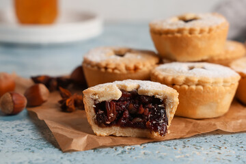Board with Christmas tasty mince pies on grunge blue background