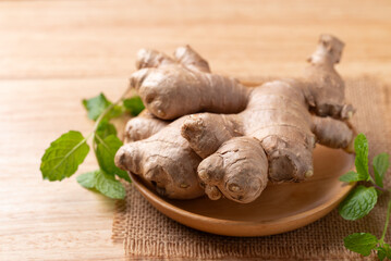 Fresh ginger with mint leaf on wooden background