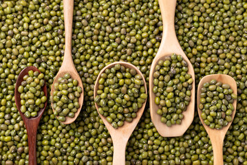 Mung bean in difference wooden spoon with mung bean seed background, Asian food ingredient