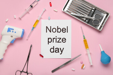 Paper with text NOBEL PRIZE DAY and medical tools on pink background