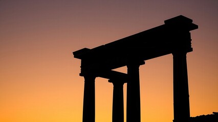 Classical Greek column silhouette against twilight sky with warm golden hour lighting