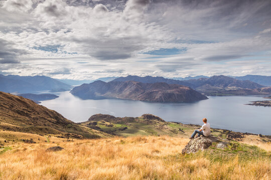 Man looking at landscape with lake and mountains, New Zealand