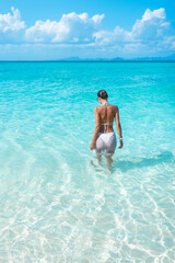 Tanned Woman In Bikini Entering Shallow Sea On Tropical Bamboo Island