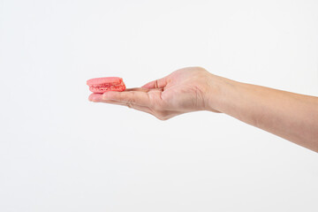 Pink macarons in hand on white background