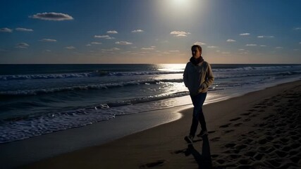 A man walks along a serene beach shore during a beautiful sunset or moonlit evening with gentle ocean waves. - Powered by Adobe