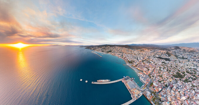 Kusadasi, Turkey. Aerial panoramic view with sun, bay, marina, beaches with promenade, port and cruise ship. Summer coastal scenery. Aerial view. - Powered by Adobe