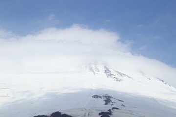 Mount Elbrus in clouds and fog in midsummer