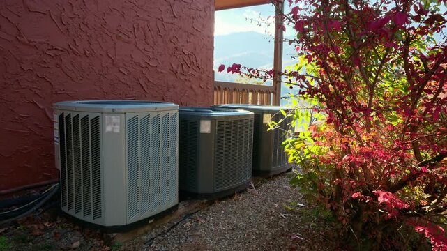 Home HVAC Air Conditioner system outside the house. Bright autumn sunny day with beautiful foliage.