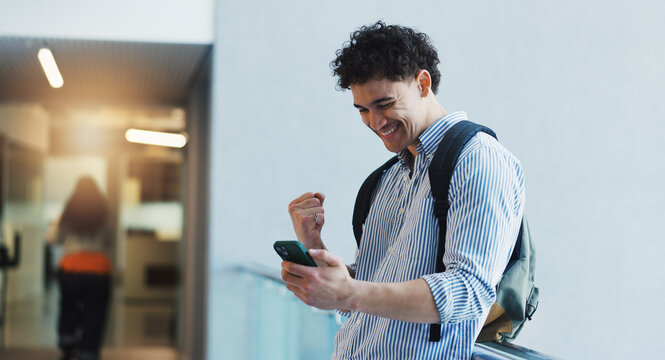 Education, fist pump and phone with student man in university hallway as scholarship winner. App, celebration and success with happy learner on college campus for good news of school bursary award