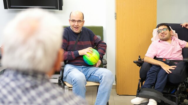 Three men enjoying inclusive activity with a colorful ball