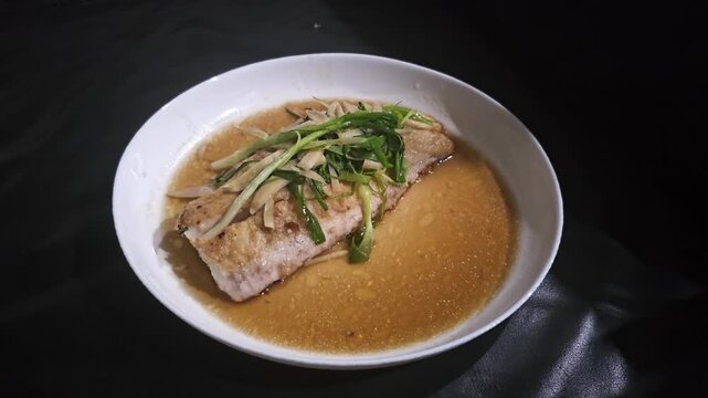 chickenTim Ikan,Steamed snapper fish with soybean sauce in a plate,Fish in soysauce noodle soup