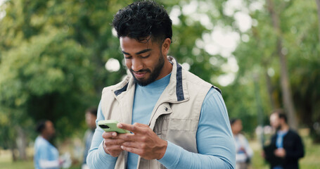 Agenda, phone and volunteer with man in park for charity, community outreach or food drive. App, schedule and typing with happy person outdoor for activism, donation or non profit communication