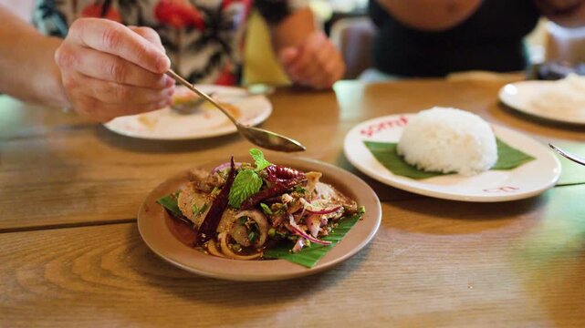 Serving Spicy Thai Pork Salad with Rice in Bangkok Restaurant