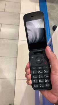 Man Opening a Dumbphone With One Hand. One-Handed Opening of an Old Dumbphone