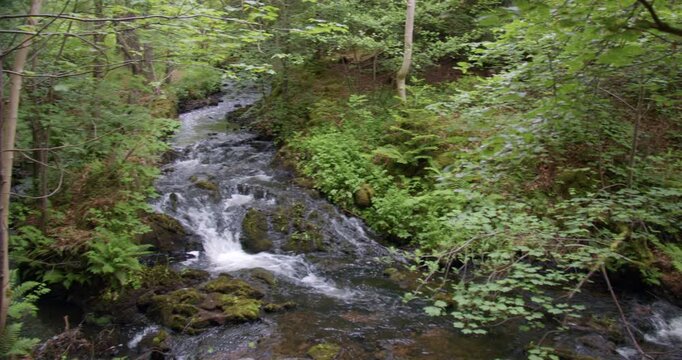 Wide panning shot right to left shot of a small waterfall on Dess burn