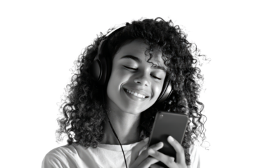 Young Woman Wearing Large Headphones Smiling While Using Smartphone in Studio Setting