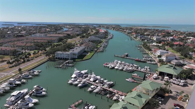 Aerial drone view of luxury waterfront condos and marina along Pine Key Cutoff in Tierra Verde, Saint Petersburg, Florida, showcasing boats, docks, and coastal residential living.