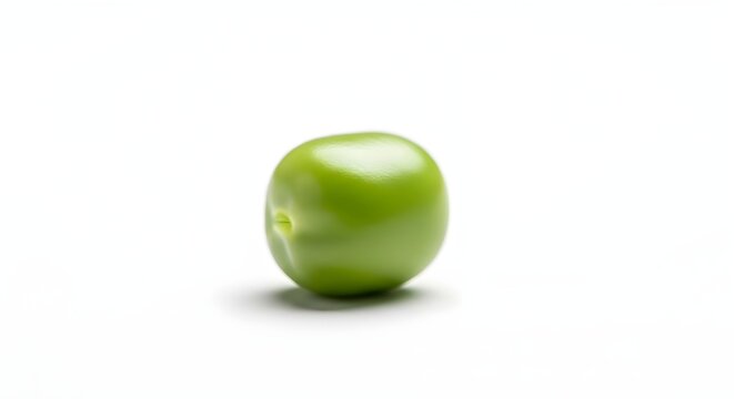 A single vibrant green pea sits isolated against a white background.