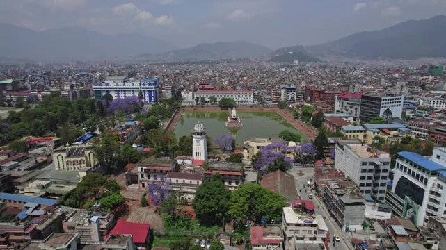 Drone view of Kathmandu Valley featuring Rani Pokhari, Ghantaghar, and blooming Jacaranda flowers, showcasing the valley&rsquo;s rich heritage, colors, and timeless urban charm.