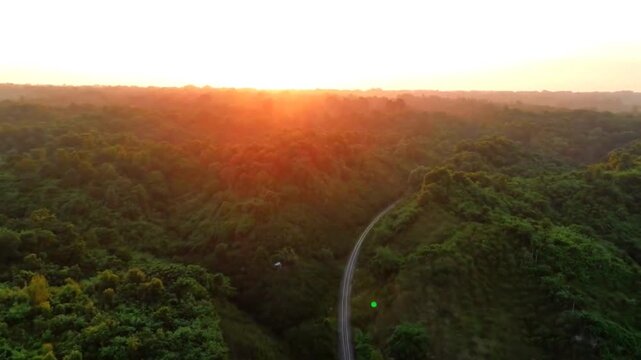 Aerial view of a railway track through a lush forest at sunset in sylhet