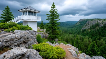 White fire lookout tower standing on a rocky mountain peak
