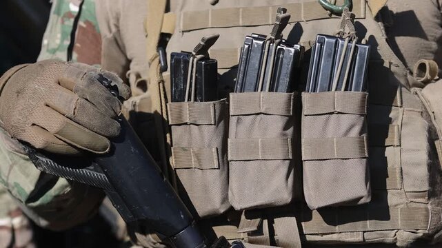 Details with the military vest, ammo mags and gun of a french soldier.