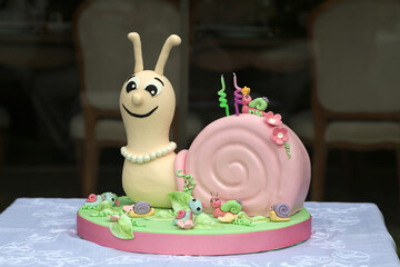 Cute Snail-Themed Fondant Cake for Kids’ Birthday,A charming, snail-themed fondant cake designed for children’s celebrations. The cake features a smiling snail character with a pink shell adorned with