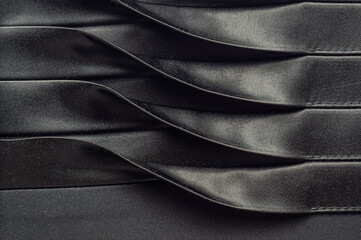 Elegant black fabric with pleats and a satin sheen, perfect for fashion design