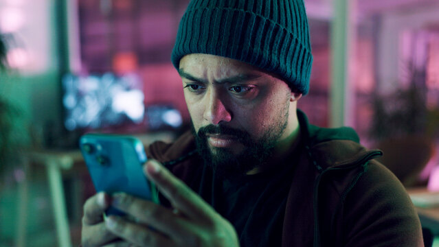 Night, hacker and man with smartphone, internet and online reading with cybersecurity programming. Person, mobile user and programmer with cellphone, website server and install malware code with scam