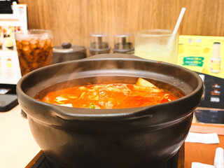 Hot vegetable soup or hearty dinner stew in a red cooking pot is a healthy traditional meal