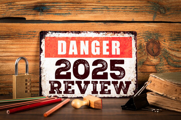 2025 Review. Danger Sign on Rustic Desk with Lock, Stamps, and Stationery