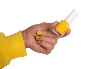 Close-up of a hand holding a bottle of yellow nail polish on transparent. Bright, modern concept for beauty, cosmetics, and manicure themes.