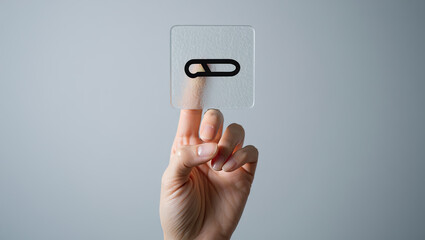 Conceptual Paperclip Icon Held in Hand A Symbolic Representation of Connection and Organization with a Modern Transparent Design Element Against Neutral Backdrop