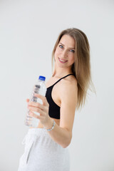 Smiling Woman in Sportswear Offering Water Bottle for Hydration