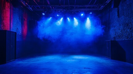 Light beams fill a spacious performance venue with blue smoke and dramatic ambiance for an upcoming event at night