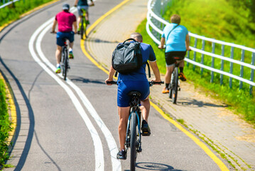 Cyclists ride on the bike path in the city Park