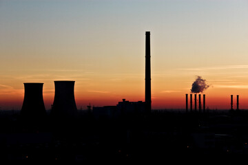sunset over the city Displays an industrial scene at sunset. Full-frame composition, orange-black tone. Realistic style, urban background