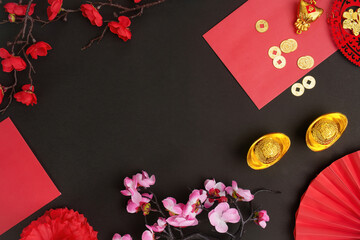 Chinese New Year decorations with red envelopes and gold coins on dark background