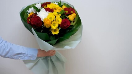 Female hand holds a bouquet of flowers on gray background close-up, - Powered by Adobe