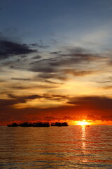 Naklejka premium Sunset boat floating over the peaceful tropical sea