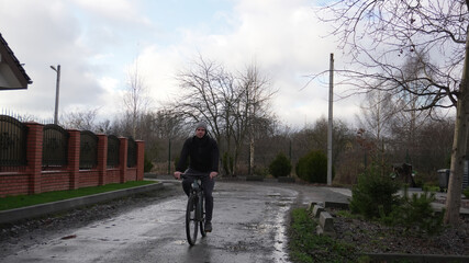 Cycling in cold weather. A man rides along a cold autumn street.