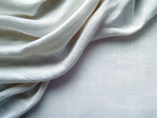A close-up view of draped white linen fabric, showcasing its soft texture and elegant folds with subtle shadows.