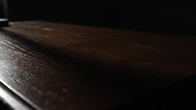 Close-up shot of a dark brown wooden surface with subtle light and shadow details