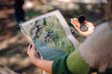 Person navigating outdoors using map and compass
